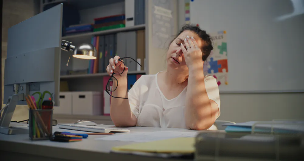 Frau ersch&ouml;pft am Schreibtisch