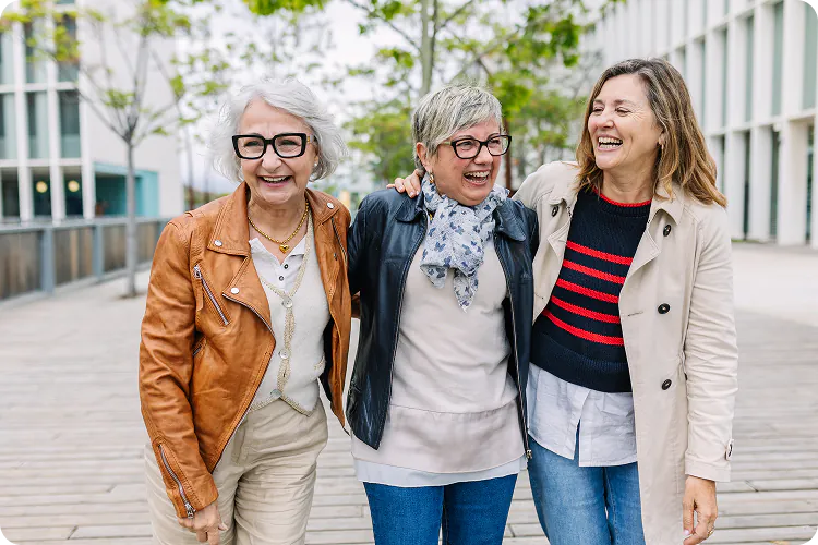 Drei Frauen lachen gemeinsam draußen